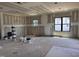 A large living room under construction with many windows, drywall, and bare floors at 240 Noramac Ct, Selma, NC 27576