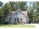Charming home with gray siding, stone accents, and lush landscaping in a serene, tree-lined setting at 2471 Golden Forest Dr, Franklinton, NC 27525
