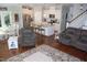 Open-concept living space with hardwood floors and a view into the modern kitchen at 2471 Golden Forest Dr, Franklinton, NC 27525