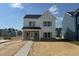 Newly constructed two-story home with white siding and brick accents under a bright blue sky at 257 Marvel Dr # 135, Rolesville, NC 27571