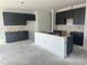 Contemporary kitchen with dark cabinets and a center island awaiting countertop installation and finishing touches at 257 Marvel Dr # 135, Rolesville, NC 27571