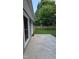 The backyard has a concrete patio, wooden fence, and lots of green grass and beautiful green trees at 2725 Westchester Dr, Burlington, NC 27217