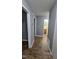 Hallway with wood floors leads to a bathroom with neutral paint and white trim at 2725 Westchester Dr, Burlington, NC 27217