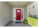 Inviting home entrance with a vibrant red door, side windows, and well-maintained landscaping at 274 Marsh Creek Dr, Garner, NC 27529