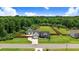 Aerial shot of a gray home with a large lot, a long driveway, and a wooded backdrop at 282 Brodie Rose Landing Way, Smithfield, NC 27577
