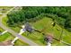 An aerial view of the property with a large, fenced backyard, modern home design, and lush surrounding greenery at 282 Brodie Rose Landing Way, Smithfield, NC 27577