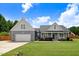 Charming home featuring a well-manicured lawn, two-car garage, and inviting front porch with rocking chairs at 282 Brodie Rose Landing Way, Smithfield, NC 27577