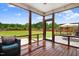 Covered porch with wood flooring offers serene views of the landscaped backyard at 282 Brodie Rose Landing Way, Smithfield, NC 27577