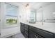 Bathroom with double vanity, dark cabinetry, white countertops, and a bright window view at 283 Daniel Ridge Rd, Wendell, NC 27591