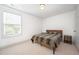 A bright bedroom has neutral carpet, white walls, and a window letting in natural light at 283 Daniel Ridge Rd, Wendell, NC 27591
