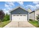 Garage with white door and black hardware against a blue house and landscaped lawn at 283 Daniel Ridge Rd, Wendell, NC 27591
