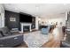 Open-concept living space featuring a fireplace, modern furniture, and seamless flow to the kitchen at 283 Daniel Ridge Rd, Wendell, NC 27591