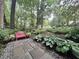 Beautiful backyard with a pink bench, stone path, lush plants, and hydrangea at 2900 Sylvania Dr, Raleigh, NC 27607