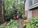 Charming backyard nook with a red chairs, stone path, lush garden, and door at 2900 Sylvania Dr, Raleigh, NC 27607