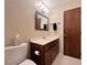 Bathroom features a vanity with marble countertop, wooden cabinets, and modern lighting fixture above the mirror at 2900 Sylvania Dr, Raleigh, NC 27607