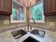 Close-up of a kitchen sink with stainless steel basin and faucet under double windows at 2900 Sylvania Dr, Raleigh, NC 27607