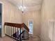 Staircase featuring carpeted steps and a wooden handrail, with a decorative chandelier above at 2900 Sylvania Dr, Raleigh, NC 27607