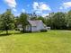 Well-maintained home with lush green lawn, mature trees, outbuilding and blue siding at 304 Foxcroft Dr, Timberlake, NC 27583
