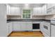 Bright kitchen featuring white cabinets, wood flooring, and stainless steel appliances at 304 Foxcroft Dr, Timberlake, NC 27583