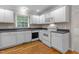 Well-lit kitchen with white appliances, cabinets, and wood flooring at 304 Foxcroft Dr, Timberlake, NC 27583
