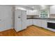 Well-lit kitchen with white cabinetry, hardwood floors and modern appliances at 304 Foxcroft Dr, Timberlake, NC 27583