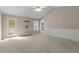 Bright, carpeted living room featuring neutral walls, a ceiling fan, and white trim detail at 304 Foxcroft Dr, Timberlake, NC 27583