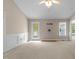 Living room with neutral paint, wainscoting, a ceiling fan, and a back door at 304 Foxcroft Dr, Timberlake, NC 27583