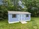 Exterior shot of a well-built blue storage shed with black framed windows and a convenient ramp entrance at 304 Foxcroft Dr, Timberlake, NC 27583