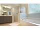 Bright bathroom offers a soaking tub and glass-enclosed shower at 308 Wescott Ridge Dr, Holly Springs, NC 27540