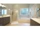 Relaxing bathroom featuring a soaking tub, separate shower, and dual vanities at 308 Wescott Ridge Dr, Holly Springs, NC 27540