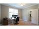 This carpeted bedroom has a closet, a window and a white desk with a laptop at 308 Wescott Ridge Dr, Holly Springs, NC 27540