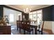Formal dining room with dark blue walls, elegant chandelier, and large windows perfect for entertaining guests at 308 Wescott Ridge Dr, Holly Springs, NC 27540