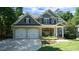 Charming two-story home with stone accents, a two-car garage and a covered front porch at 308 Wescott Ridge Dr, Holly Springs, NC 27540