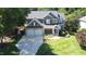 Charming two-story home with a well-manicured lawn, stone accents, and a two-car garage, exuding curb appeal at 308 Wescott Ridge Dr, Holly Springs, NC 27540