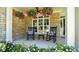 Inviting front porch with stone facade, rocking chairs, and blooming flower baskets for relaxing curb appeal at 308 Wescott Ridge Dr, Holly Springs, NC 27540