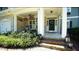 Inviting front porch with stone accents, hanging plants, and comfortable seating, creating a welcoming entrance at 308 Wescott Ridge Dr, Holly Springs, NC 27540