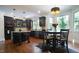 Modern kitchen with dark cabinetry, granite countertops, island, and breakfast nook offering stylish functionality at 308 Wescott Ridge Dr, Holly Springs, NC 27540
