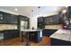 Well-appointed kitchen features granite island, stainless steel appliances, and dark cabinets for culinary enthusiasts at 308 Wescott Ridge Dr, Holly Springs, NC 27540