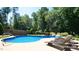 Landscaped backyard showcasing a sparkling in-ground pool, lounge chairs, and lush greenery at 308 Wescott Ridge Dr, Holly Springs, NC 27540