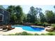 Inviting backyard pool area with lounge chairs and lush trees offers privacy and a relaxing atmosphere at 308 Wescott Ridge Dr, Holly Springs, NC 27540