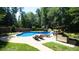 In-ground pool with waterfall feature, surrounded by lounge chairs and a covered outdoor bar, perfect for summer gatherings at 308 Wescott Ridge Dr, Holly Springs, NC 27540