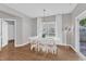 The dining room has hardwood floors, a white table and chairs, white curtains, and a hanging light fixture at 3119 Guiding Light Rd, Raleigh, NC 27610