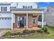 Welcoming front porch with brick accents, a cozy entrance, and landscaped garden at 3119 Guiding Light Rd, Raleigh, NC 27610