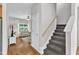 Hallway featuring hardwood floors, stairs, and a view into the well-lit living room at 3119 Guiding Light Rd, Raleigh, NC 27610