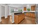 Open kitchen featuring wood cabinets, stainless steel appliances, and a breakfast bar at 3119 Guiding Light Rd, Raleigh, NC 27610