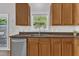 Kitchen with a window over stainless steel sink, brown cabinets and countertops, and stainless steel dishwasher at 3119 Guiding Light Rd, Raleigh, NC 27610