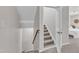 Carpeted staircase leading from the second floor to the first floor, with white trim at 3119 Guiding Light Rd, Raleigh, NC 27610