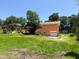 Back exterior showing a well maintained red brick house with a green door and ample green space at 3323 Baugh St, Raleigh, NC 27604