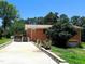 Back exterior of brick house with a driveway, landscaping materials, and garage door at 3323 Baugh St, Raleigh, NC 27604