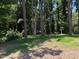 Expansive backyard featuring lush green grass, a perimeter of mature trees, and dappled sunlight at 3323 Baugh St, Raleigh, NC 27604